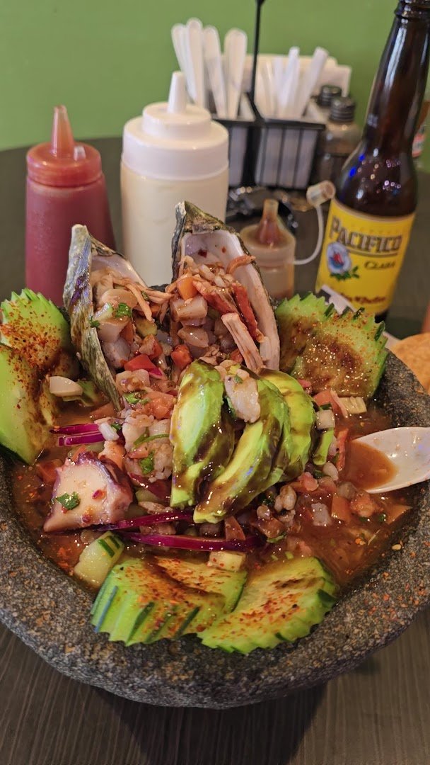 Colorful mariscos plates with sauces and sides.
